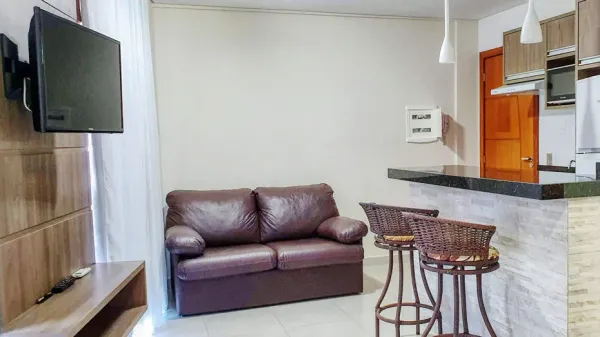 Área social dos Lofts 102 e 202 com sofá-cama e TV